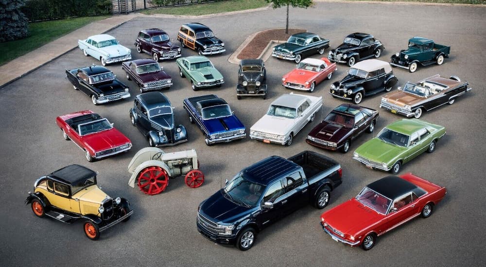 A line up of 100 years of Ford cars are shown at a Ford dealer event.