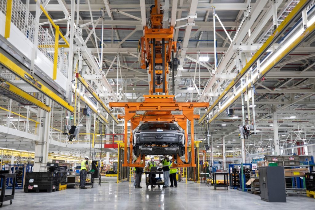 Factory workers are shown manufacturing a Ford Lightning.