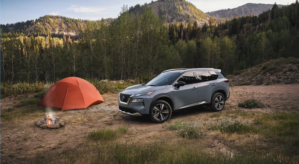 A silver 2021 Nissan Rogue is shown parked outside of a remote campsite.