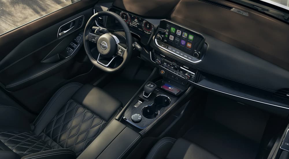 The black leather interior of a 2021 Nissan Rogue is shown at a Nissan Rogue dealer.