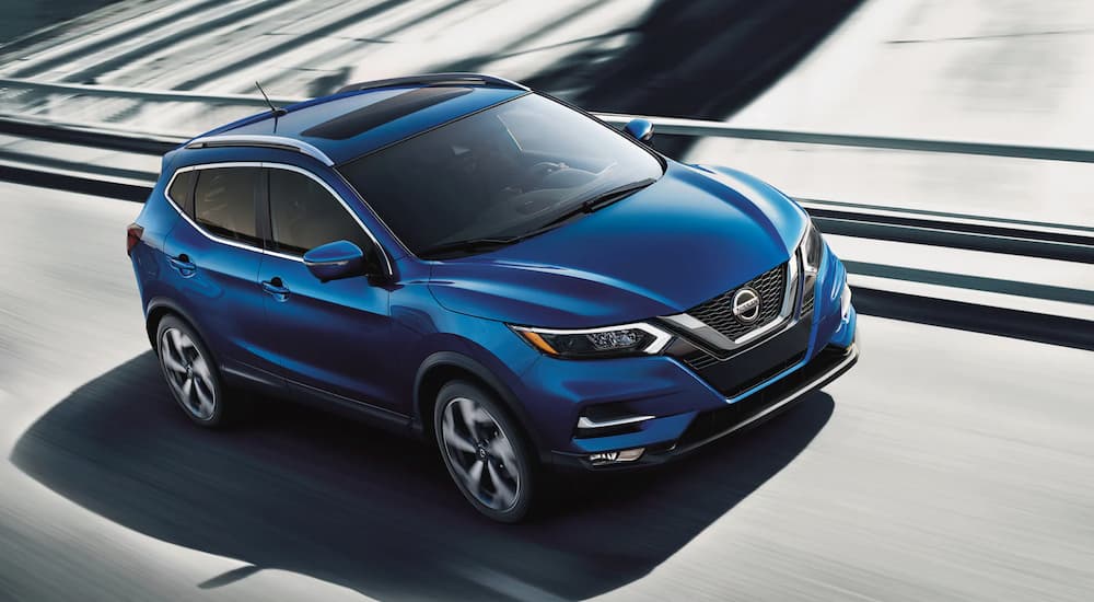 A blue 2021 Nissan Rogue Sport is shown leaving a Nissan Rogue dealer.