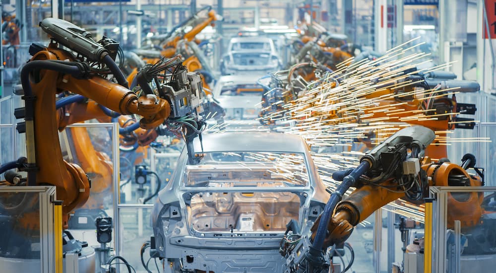 A car manufacturing assembly line is shown from a high angle.