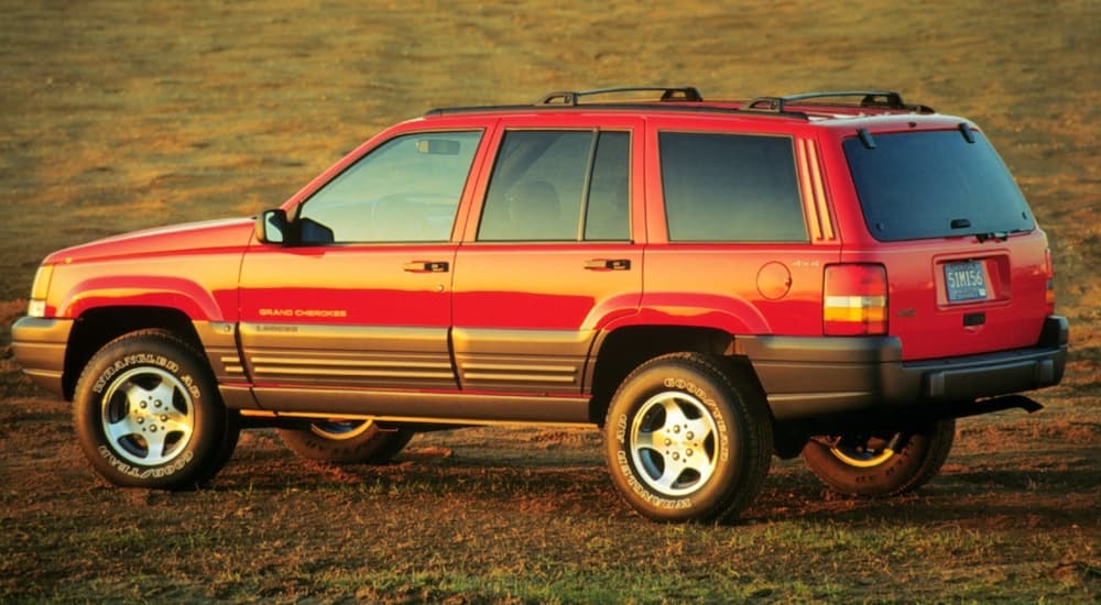 A red 1996 Jeep Grand Cherokee is shown parked in a grassy field.