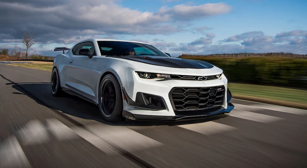 A white and black 2022 Chevy Camaro ZL1 1LE is shown driving on a racetrack.