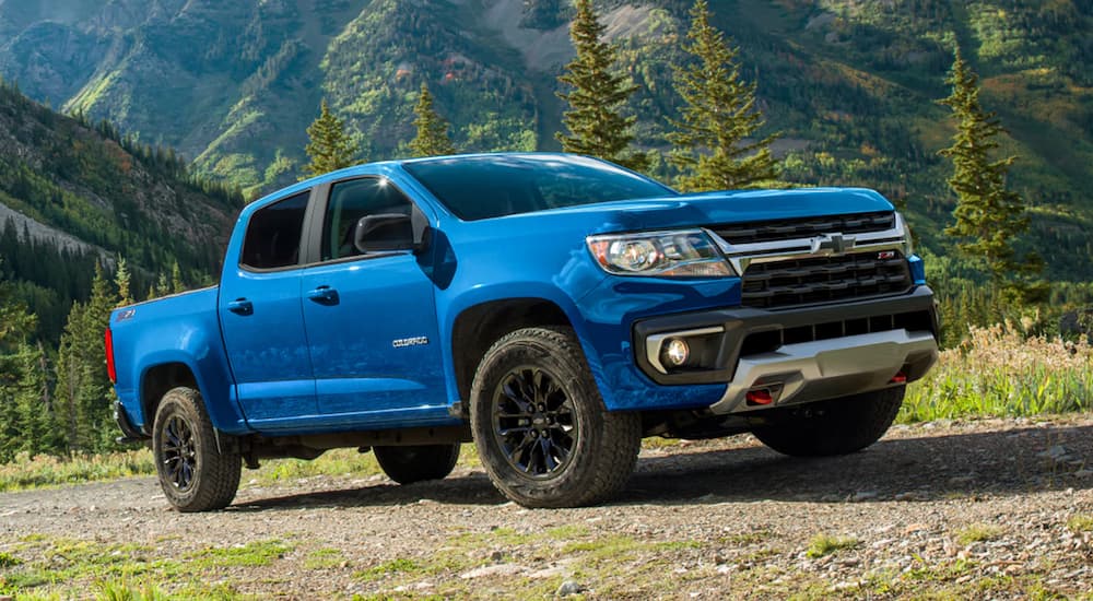 A blue 2022 Chevy Colorado Z71 is shown parked on grass in the mountains.
