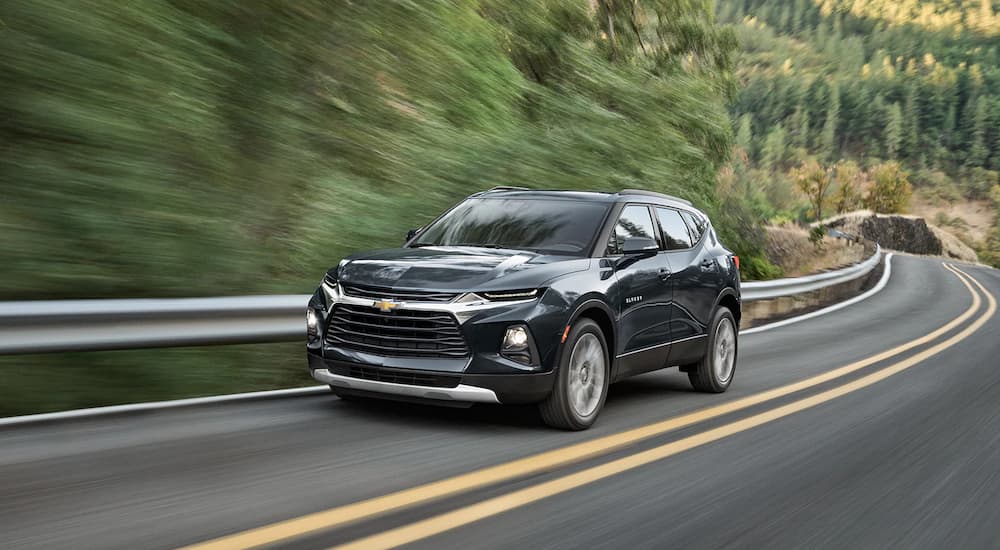 A black 2022 Chevy Blazer is shown driving down an empty highway.