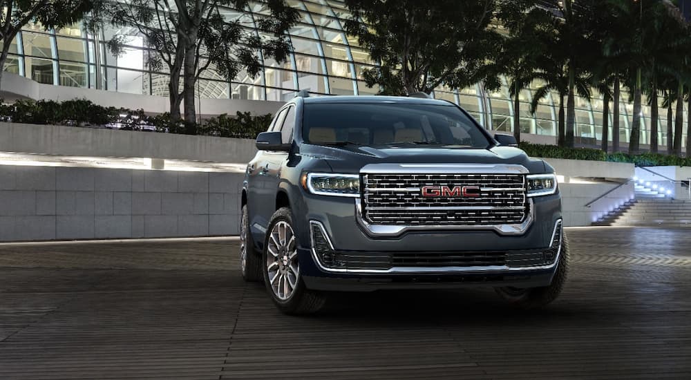 A grey 2022 GMC Acadia is shown parked near a glass building. is shown parked outside