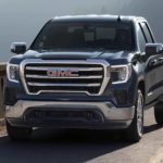 A blue 2022 GMC Sierra 1500 is shown driving on a highway.