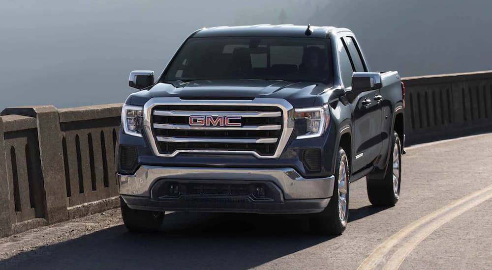 A blue 2022 GMC Sierra 1500 is shown driving on a highway.
