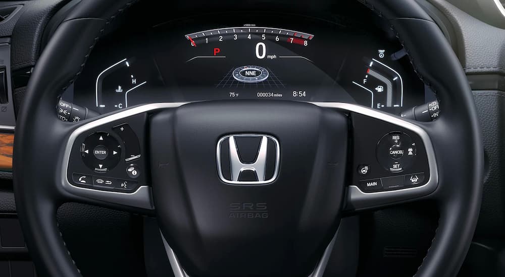 A close up shows the steering wheel and dashboard of a 2022 Honda CR-V Touring.