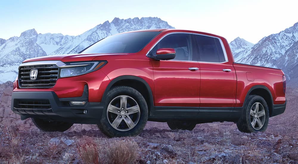 A red 2022 Honda Ridgeline RTL-E is shown parked in a rocky area.