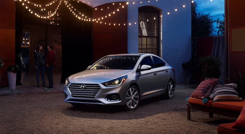 A silver 2022 Hyundai Accent is shown parked under lights in a courtyard.