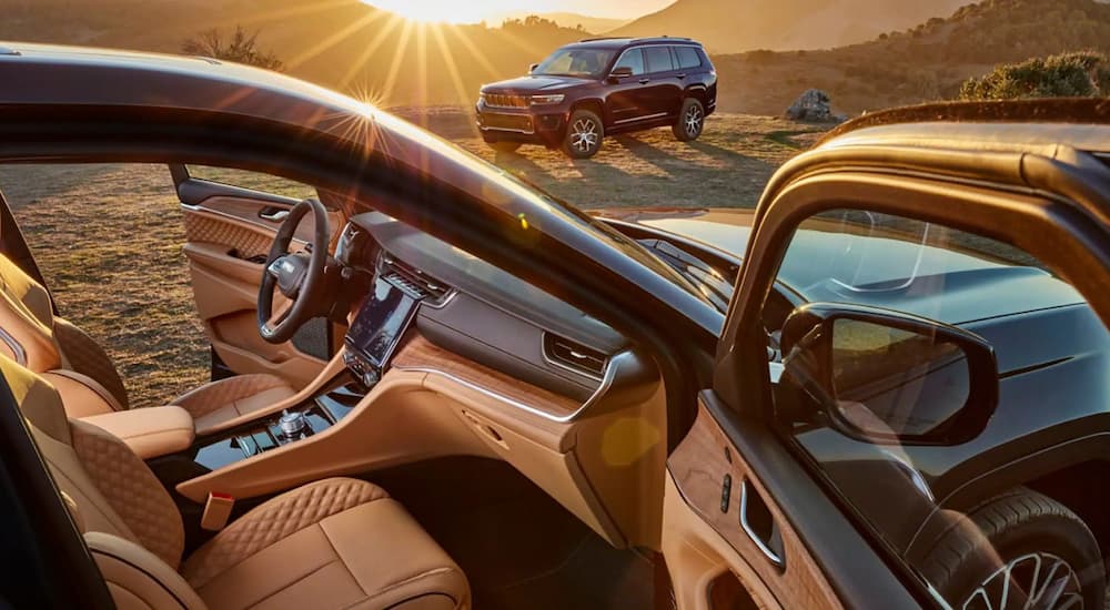 The tan interior of a 2022 Jeep Grand Cherokee L Summit is shown with the doors open.