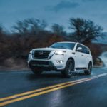 A white 2022 Nissan Armada is shown driving in a rainstorm.