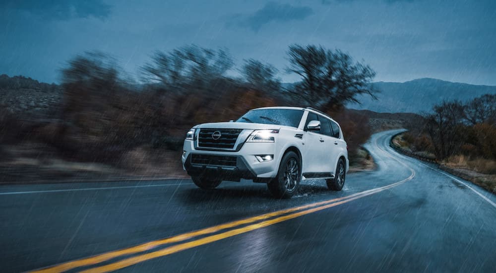 A white 2022 Nissan Armada is shown driving in a rainstorm.