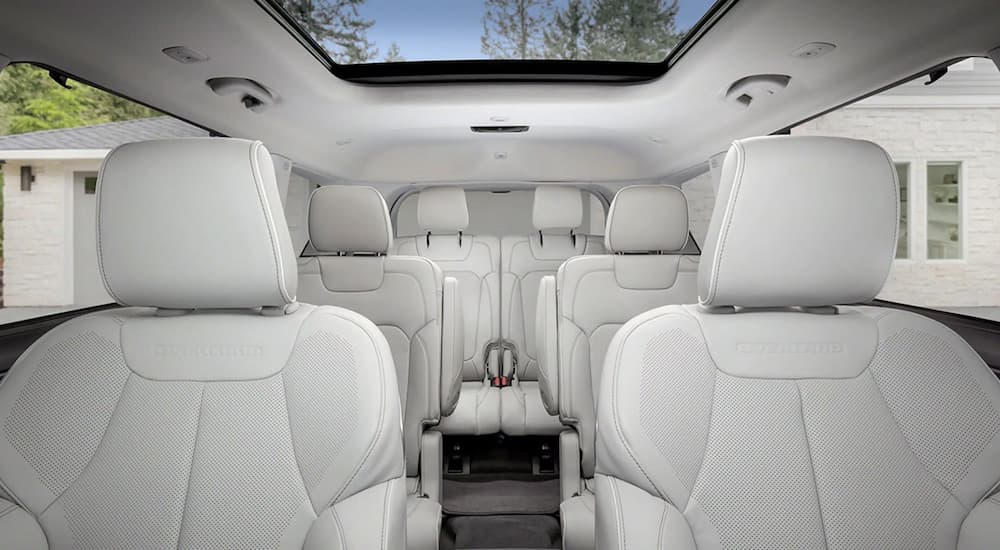 The white interior of a 2022 Jeep Grand Cherokee L Overland shows three rows of seating.