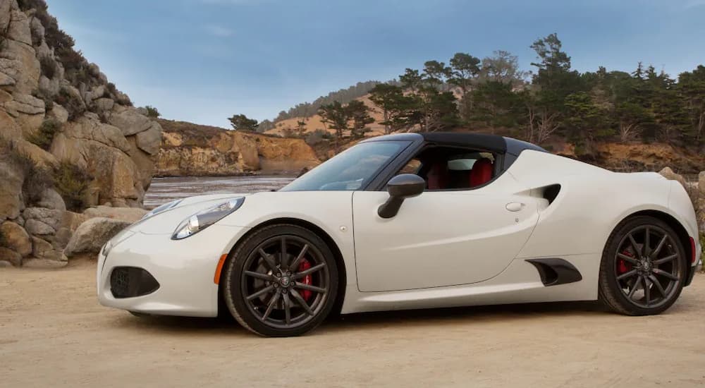 A white 2020 Alfa Romeo 4C Spider is shown parked on a sandy area.