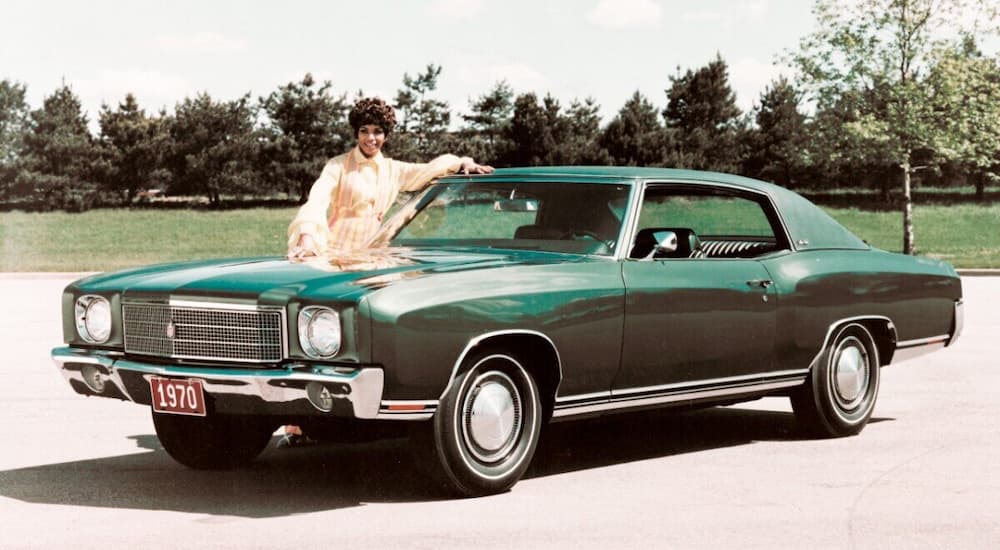 A green 1970 Monte Carlo is shown parked by a grassy area.