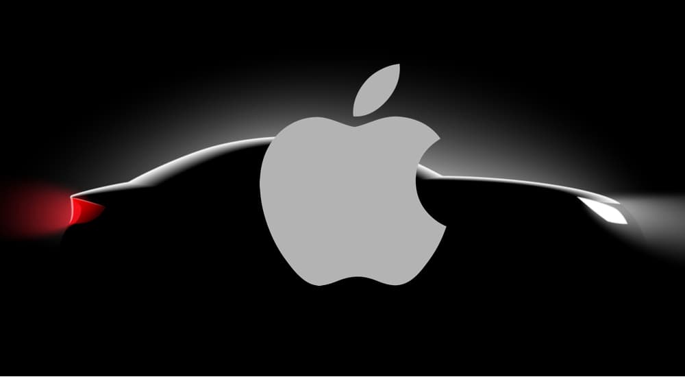 The Apple logo is shown on top of a dark silhouette of a car.