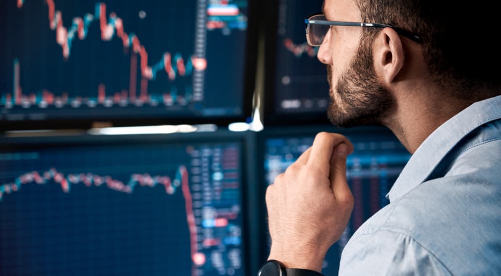 A man is shown analyzing stocks.