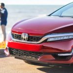 A red 2022 Honda Clarity Fuel Cell is shown parked by a body of water.