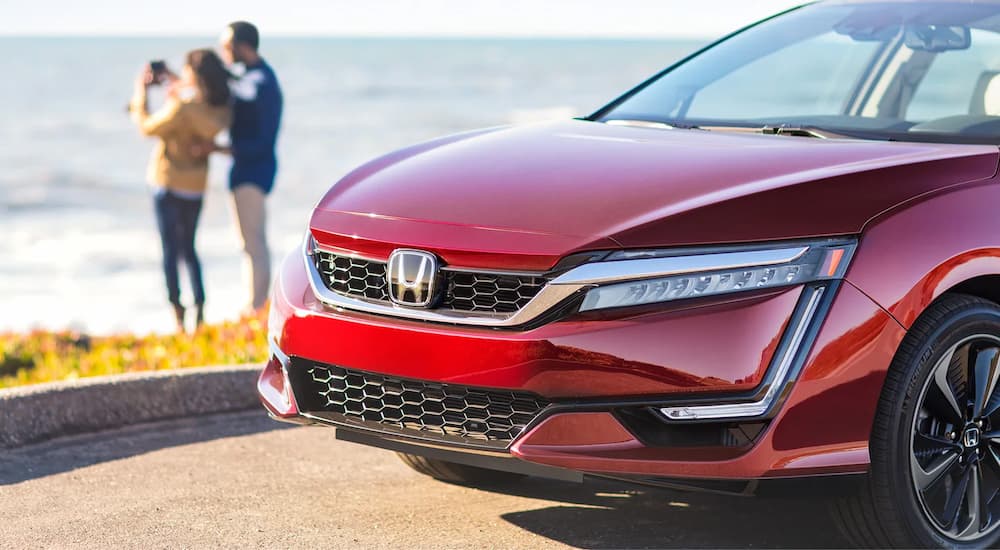 A red 2022 Honda Clarity Fuel Cell is shown parked by a body of water.