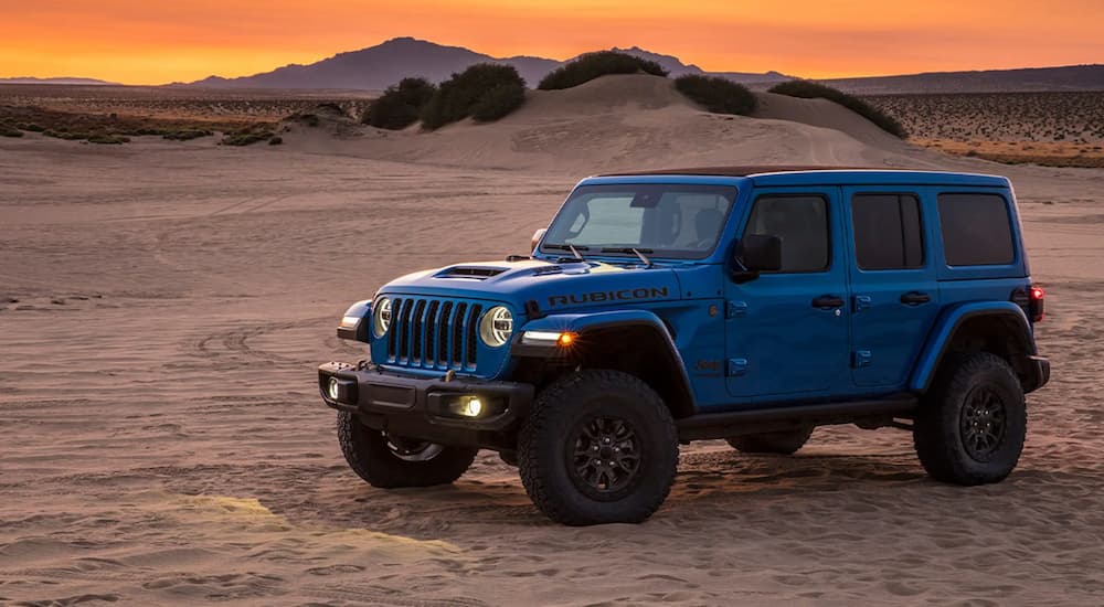 A blue 2021 Jeep Wrangler Rubicon 392 is shown parked in a desert after visiting a Jeep dealer.