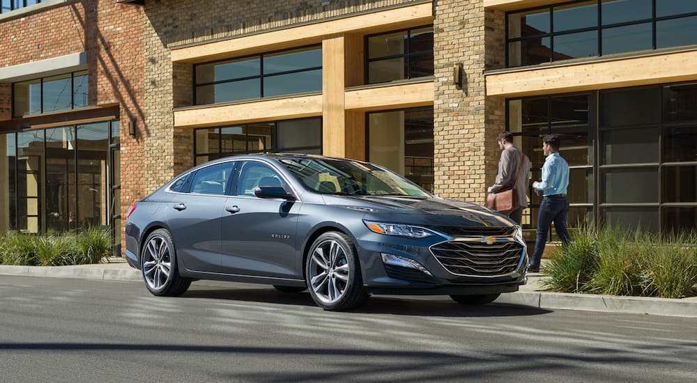 A grey 2020 Chevy Malibu is shown parked on a city side street.