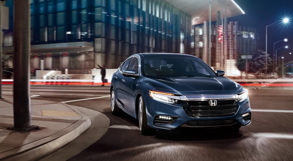 A 2021 Honda Insight Touring is shown leaving a used Honda dealer at night.