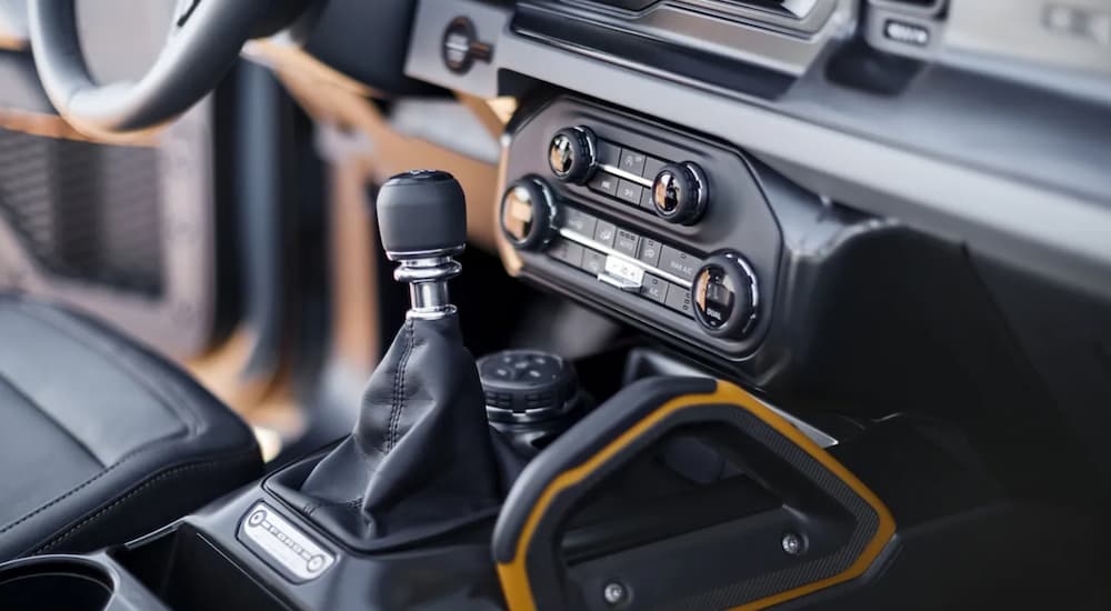 The black interior of a 2021 Ford Bronco shows the shift-stick in close up.