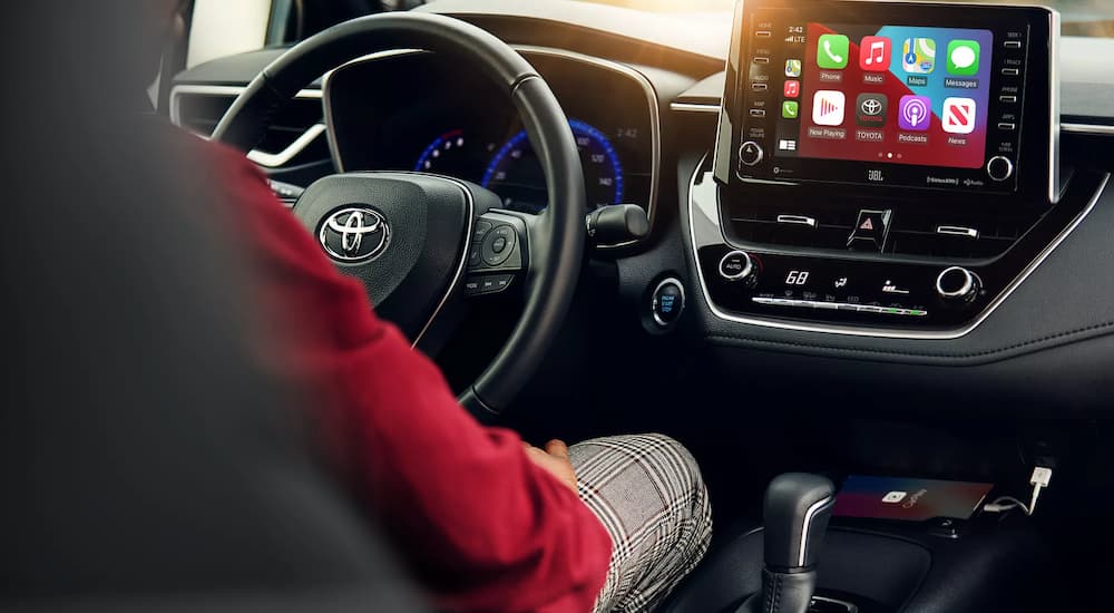 A person is shown sitting in the driver's seat of a 2021 Toyota Corolla XSE.