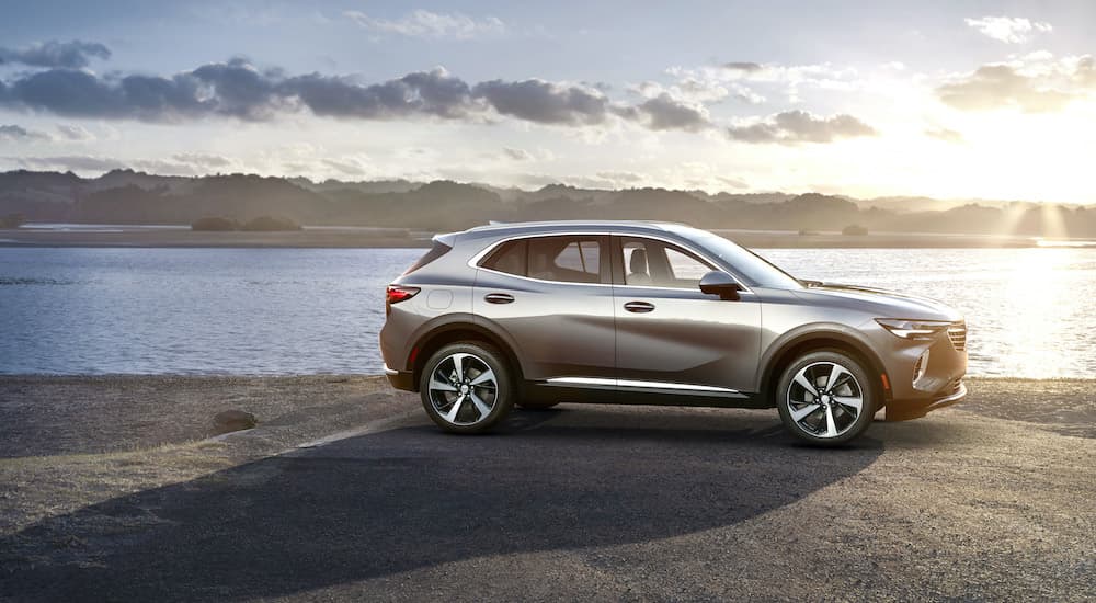 A silver 2022 Buick Envision is shown parked on a lake shore.