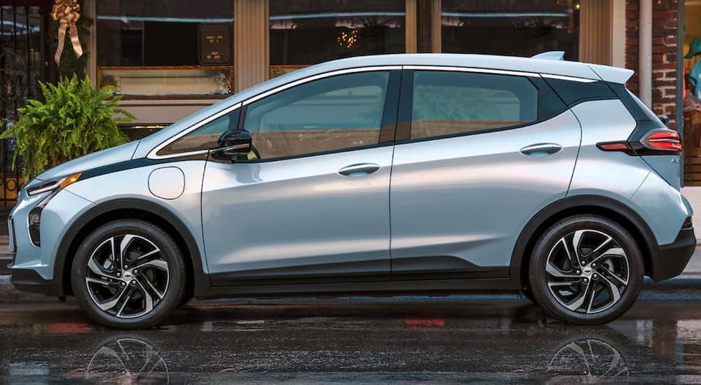 A silver 2022 Chevy Bolt EV is shown from the side after leaving a Chevy dealer.