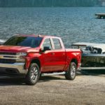 A red 2022 Chevy Silverado is shown from the front towing a boat our of a lake after winning a 2022 Chevy Silverado 1500 vs 2022 Ram 1500 comparison.