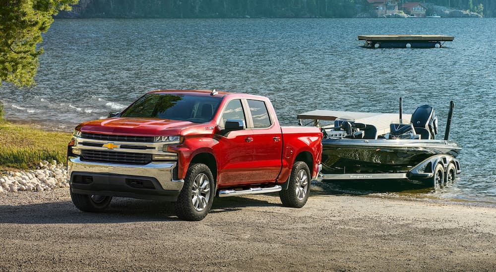 A red 2022 Chevy Silverado is shown from the front towing a boat our of a lake after winning a 2022 Chevy Silverado 1500 vs 2022 Ram 1500 comparison.