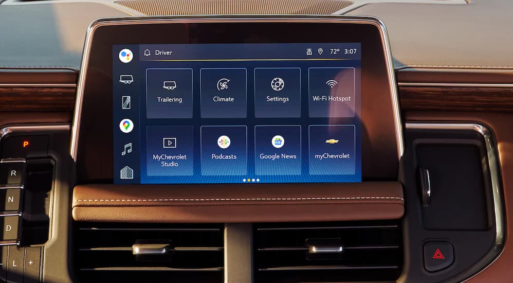 The tan interior of a 2022 Chevy Suburban shows the infotainment screen in close up.