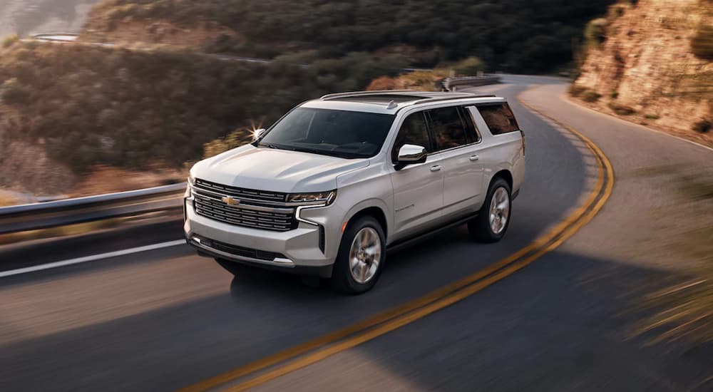 A white 2022 Chevy Suburban is shown from above driving on an open road.