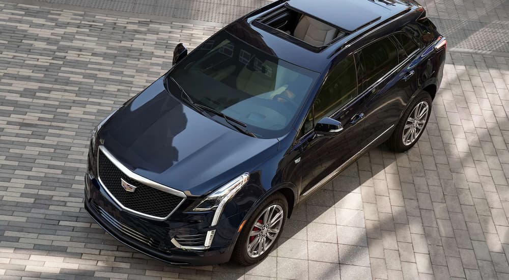 A blue 2022 Cadillac XT5 is shown from a high angle parked on a stone path.