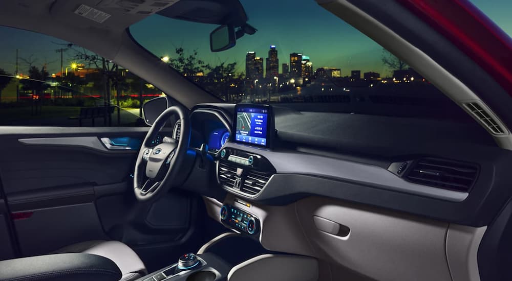 The grey interior of a 2022 Ford Escape shows the steering wheel and infotainment screen.