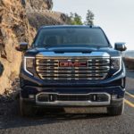 A blue 2022 GMC Sierra Denali is shown from the front driving during a 2022 GMC Sierra 1500 vs 2022 Chevy Silverado 1500 comparison.