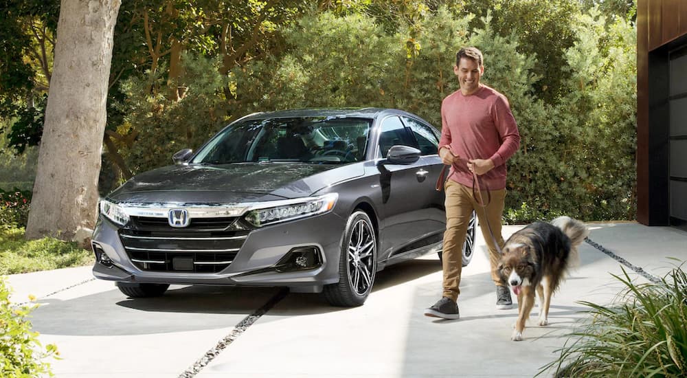 A grey 2022 Honda Accord Hybrid Touring is shown from the front parked in a driveway.