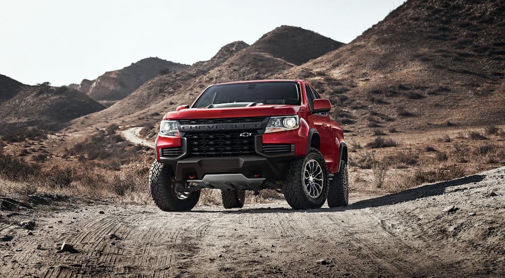 A red 2022 Chevy Colorado ZR2 is shown parked in a remote desert area during a 2022 Nissan Frontier vs 2022 Chevy Colorado comparison.