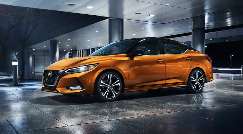 An orange 2022 Nissan Sentra is shown from the side parked in a modern gallery.