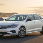 A white 2022 Volkswagen Passat Limited is shown overlooking an ocean.