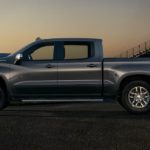 A grey 2021 Chevy Silverado 1500 is shown from the side parked at sunset.