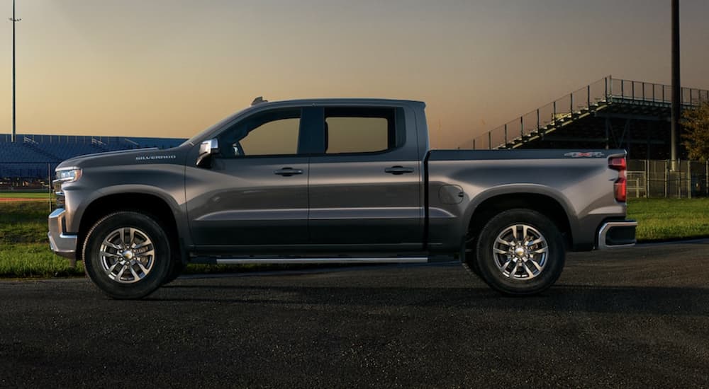 A grey 2021 Chevy Silverado 1500 is shown from the side parked at sunset.