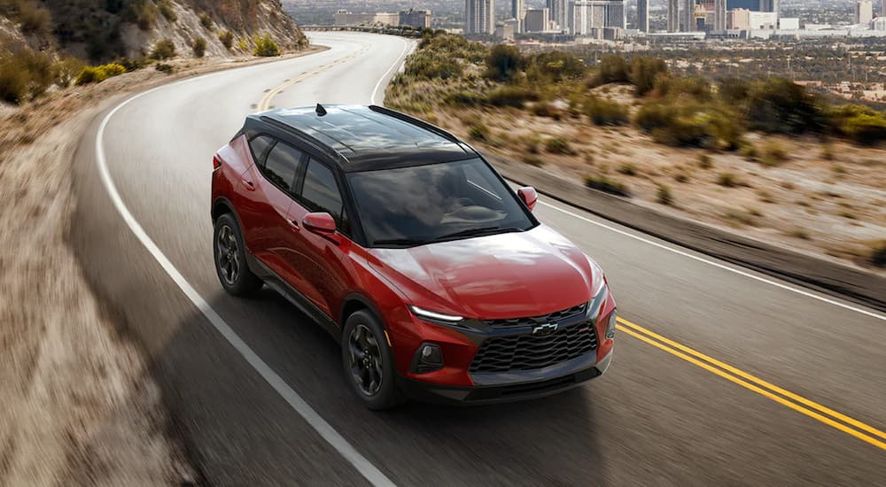 A red 2021 Chevy Blazer RS is shown driving on an open road.