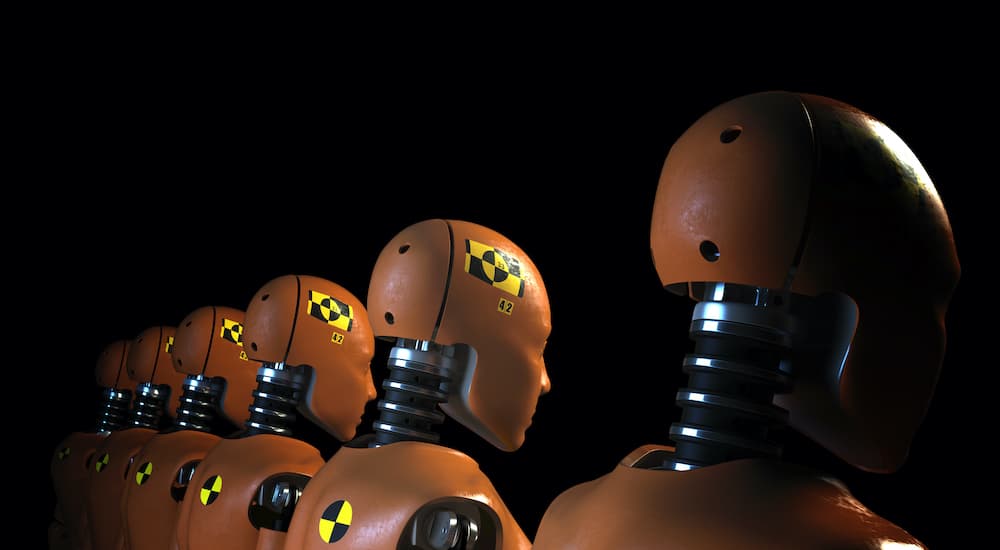 A row of crash test dummies are shown from behind.
