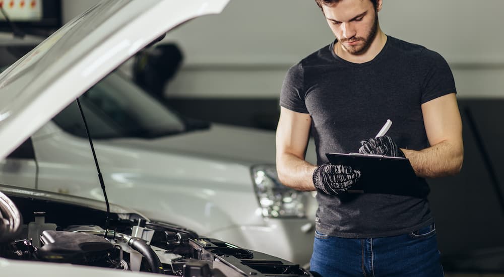 A mechanic with a clipboard is making a written estimate.