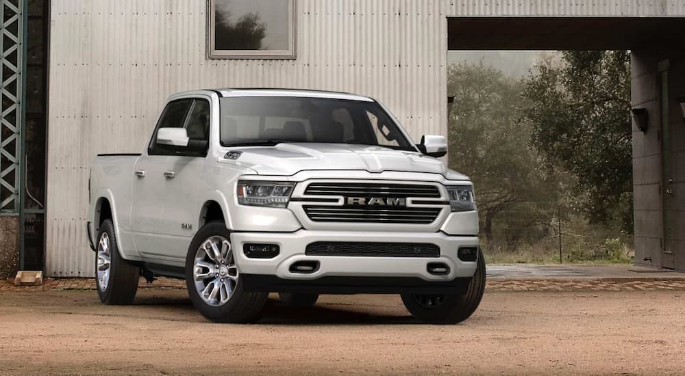 A white 2020 Ram 1500 is shown from the front parked in front of a white wall after leaving a Ram truck dealer.